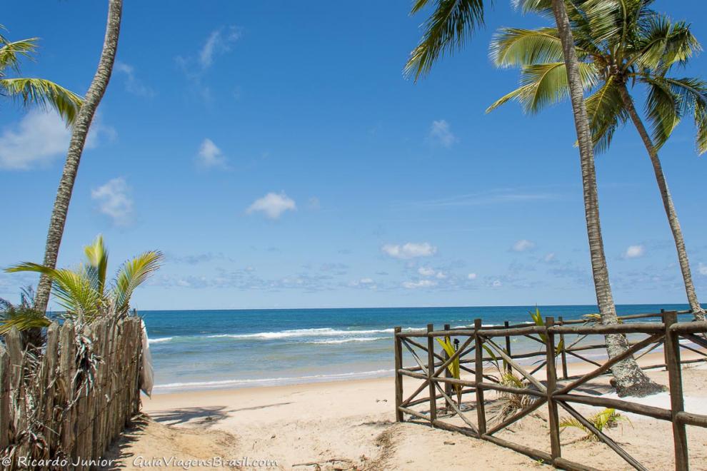 Imagem da chegada na Praia da Bombaça, mar azul encantador.